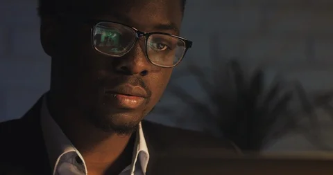 Tired of working on the computer young black man pushes up his glasses and rubs Stock Footage 107920761