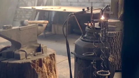 Tired young blacksmith apron in shaping hot metal with hammer 動画素材 77006131