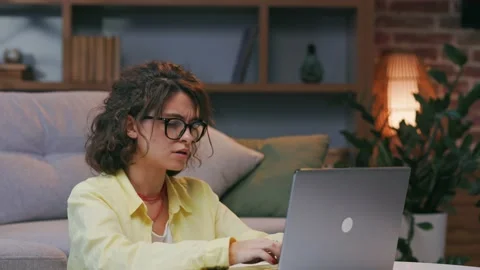 Tired young curly student worker pauses online work, takes off her glasses Stock Footage 220454055