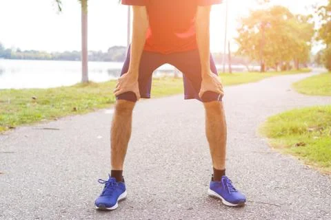 Tired young man runner taking a rest after running.workout concept Stock Photos