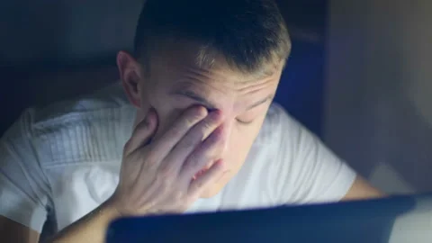 Tired young man working on a computer late at night Video stock 122695318