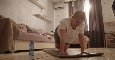 Tired young overweight lady doing buttock exercise on mat at home Stock Footage 237934679