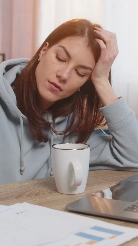 Tired young woman freelancer using laptop computer at table with documents in Stock Footage 314200144