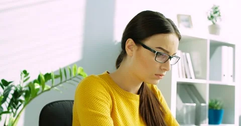 Tired young woman taking off her glasses and massaging eyes. Woman at office Stock Footage