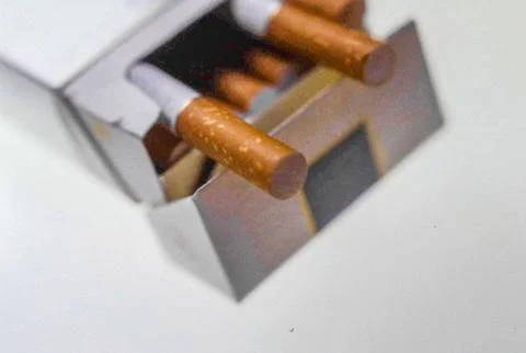 Titel:.Open cigarette pack on white background symbolizing health tax econo.. Stock Photos