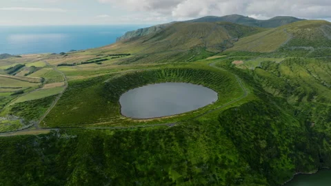 Title: Aerial drone wide view of a circular volcanic crater lake surrounded by Stockbeeldmateriaal 335245548
