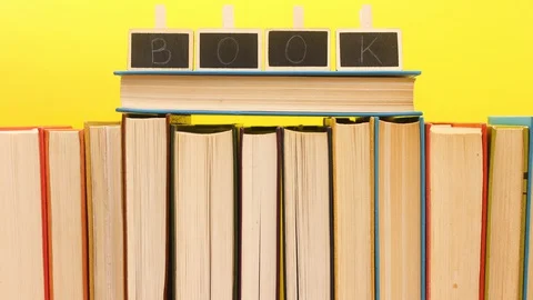 Title books appear on the ordered books on yellow background - Stop motion Vidéo 129314204