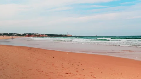 Title: Sunny Beach and Ocean Waves with Surfers in Portugal Stock-Footage 336719104