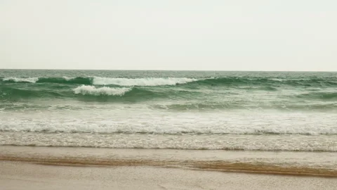 Title: Sunny Beach and Ocean Waves with Surfers in Portugal Stock-Footage 336731236