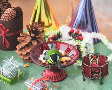 A titmouse bird eats on a table with Christmas decorations Stock Photos