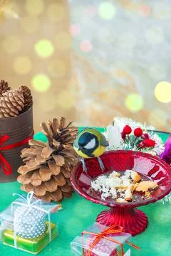 A titmouse bird eats on a table with Christmas decorations Stock Photos