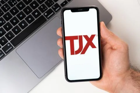 TJX mobile application on the smartphone screen. A mobile phone in a man hand Stock Photos