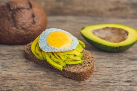 Toast with avocado and egg on rustic wooden background Stock Photos