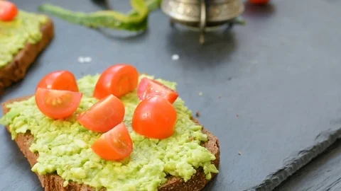 Toast with avocado, cherry tomatoes and spices Stock Footage 72586023