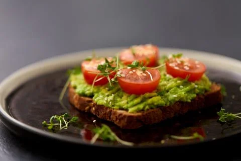 Toast bread with mashed avocado and cherry tomato Stock Photos