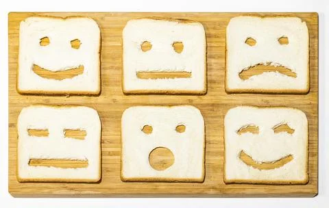 Toast bread slices with funny faces on wooden board. Bread slices with emoji Stock Photos