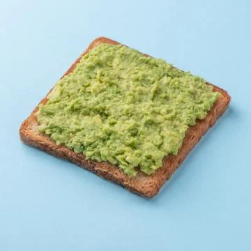 Toast with mashed avocado on blue background Stock Photos