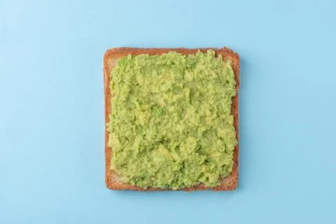 Toast with mashed avocado on blue background Stock Photos