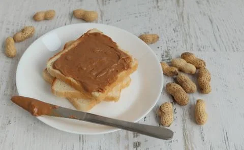 Toast with peanut paste on a white background Stock Photos