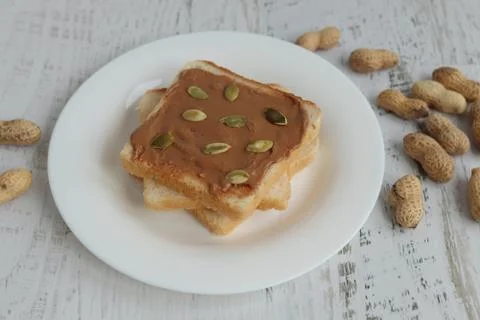 Toast with peanut paste on a white background Stock Photos