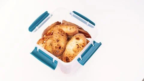 Toast in a plastic container on a white background. Toasted baguette slices Stock Photos