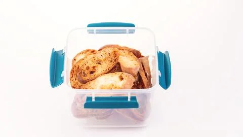 Toast in a plastic container on a white background. Toasted baguette slices Stock Photos