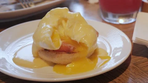 Toast with poached egg and ham close up. runny egg yolk over toast from egg b Stock Footage 198997147
