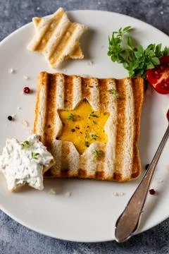 Toast with scrambled eggs in the shape of star with cheam cheese and vegetabl Stock Photos