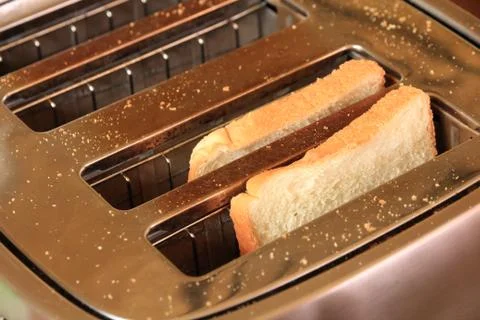 Toast in toaster in simple breakfast setting. Stock Photos