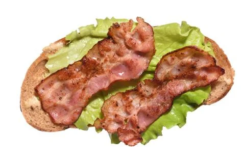 Toasted bacon on bread and a leaf of lettuce for breakfast. Close-up 스톡 사진