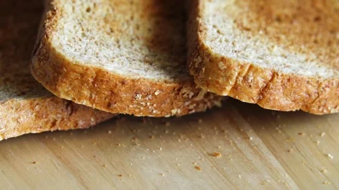 Toasted bran bread rotates in a circle on a wooden cutting board. Stock Footage 141799738