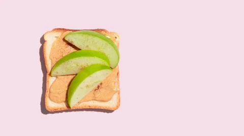 Toasted bread with apple and cinnamon on pink background. Stock Photos