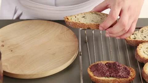 Toasted bread being spread with olive paste Stock Footage 24670593