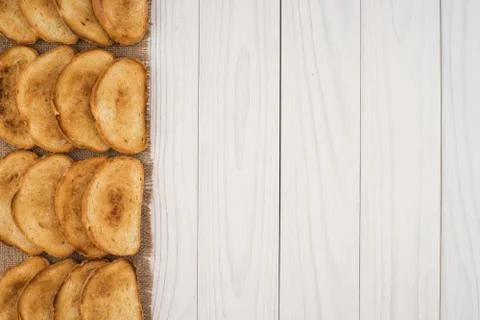 Toasted bread on burlap and a white wooden table. Stock Photos