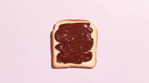 Toasted bread with chocolate on pink background. Stock Photos