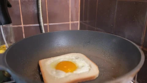 Toasted bread with egg frying on pan flipped to golden side with spatula Stock Footage 310287155