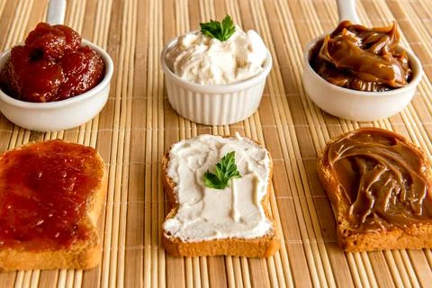 Toasted bread with jam, dulce de leche and ricotta cream on a breakfast table Stock Photos