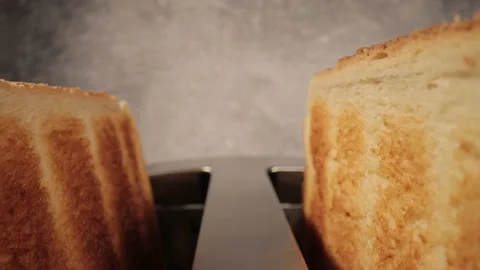 Toasted bread jumps out of a toaster - close-up shot - food photography Stock Footage 152787674