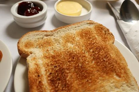 Toasted bread slice serving with strawberry jam and butter portions for bre.. 写真素材