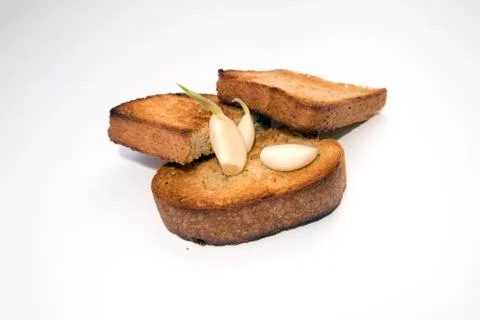 Toasted bread slices with appetite crispy crust and few sprouted garlic cloves Stock Photos