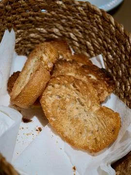 Toasted bread slices serving in a rustic woven basket Stock Photos