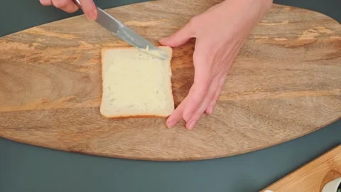 Toasted bread smeared with butter on a cutting board Stock Footage 252179364