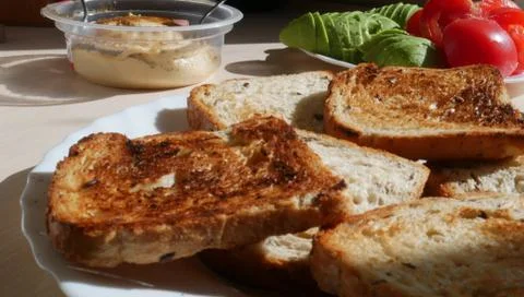 Toasted bread with tomatoes, avocado and hummus Stock Photos