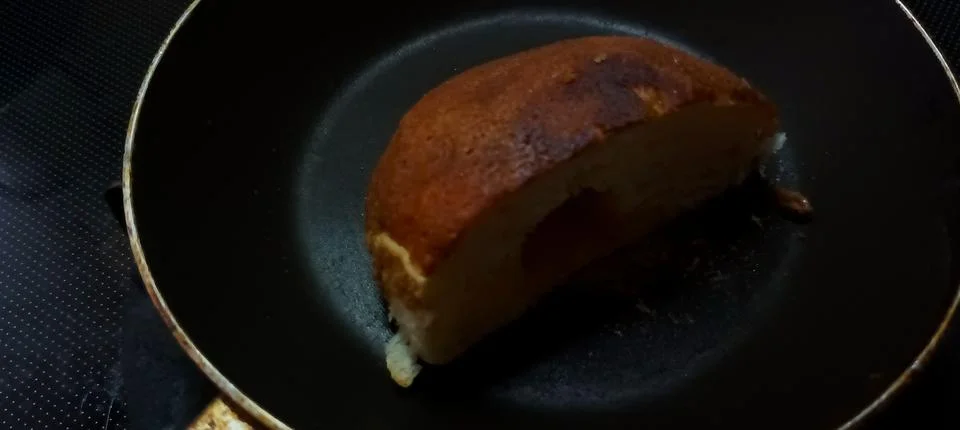 Toasted or fried bread slice in a black frying pan Foto stock