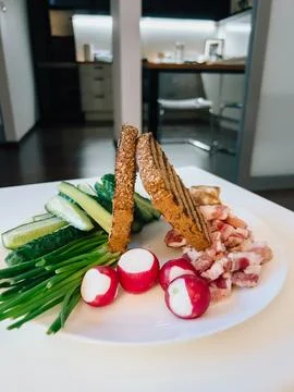 Toasted rye bread, bacon, radish, green onions and cucumber slices arranged on 스톡 사진