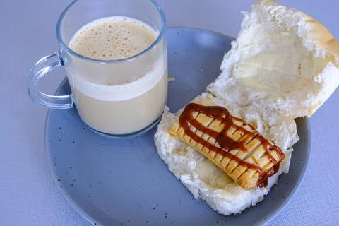 Toasted sausage roll rests on soft bread, drizzled with ketchup Stock Photos