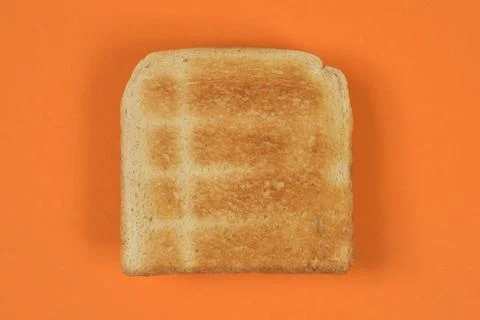 Toasted white bread slice on orange background Foto stock