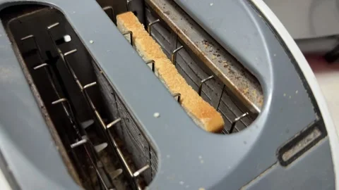 Toaster with glowing heating elements preparing bread, kitchen appliance in use, Stock Footage 337117959