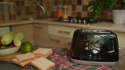 Toaster on table with golden toasted bread popping up fresh and crispy for a Stock Footage 311864311