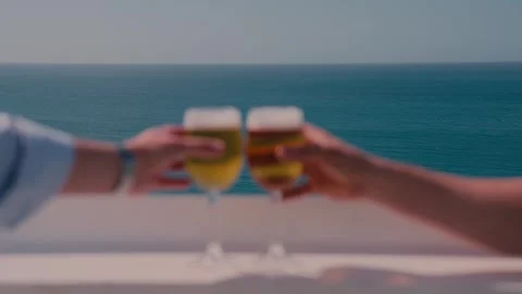 Toasting Beer Glasses on Balcony Overlooking the Sea Stock Footage 346022346